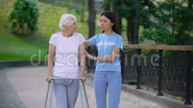 女志愿者支持生病的老妇人步行架，康复困难