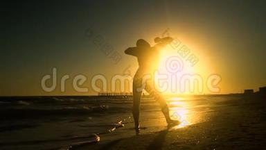 快乐的<strong>男</strong>人在海滩上跳舞。 他在阳光下跳跃。 这个人玩得很开心。 他很开心。 一个<strong>男</strong>人的<strong>剪影</strong>