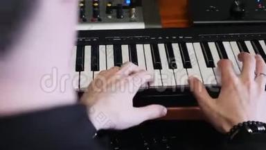 手在音乐工作室的钢琴MIDI键盘上演奏。 音乐创作过程。 流行音乐流行作曲家为音乐专辑创作新歌曲。