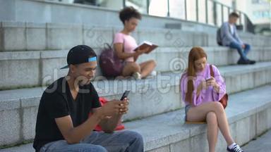 快乐的青少年在户外聊天智能手机，高中生休息