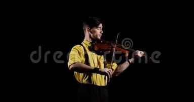 男职业小提琴手在黑色背景下拉小提琴，在黑暗中，正面观看。