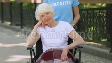义工扶助轮椅上的残疾老人，白天在医院公园
