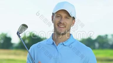 微笑高尔夫球手手持铁棍摆姿势拍照，爱好，休闲活动