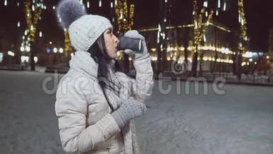 穿<strong>暖</strong>和衣服的女孩在圣诞广<strong>场</strong>喝咖啡。
