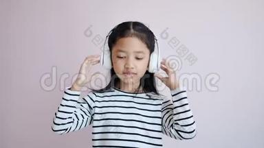 幼儿用白色耳机听音乐，并根据音乐的节奏摇一摇