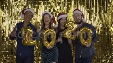 2020年 落下的金色纸屑。 4个带着金箔字母的人在金色的背景上跳舞。 红色