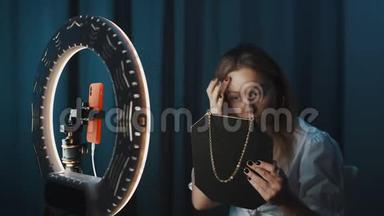 金发女人正在手里拿着镜子在戒指的前面化妆。