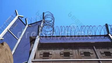 高的监狱围<strong>栏</strong>，带刺铁丝网，对抗晴朗的天空。 <strong>底部</strong>视图