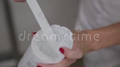专业美容师拿起一个润肤霜，用于面部。