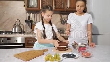 妈妈和女儿正在一起用奶油<strong>做手工</strong>蛋糕。