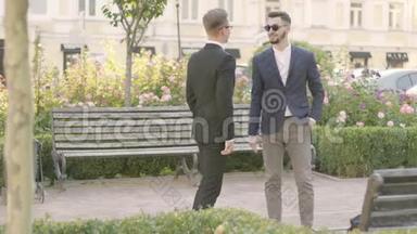 两个年轻的伙伴在公园里见面握手。 自信的经理在户外<strong>会见</strong>他的客户。 商务会议