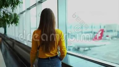 年轻的欧洲妇女在机场候机楼窗口附近打电话，<strong>错过</strong>航班后心烦意乱。