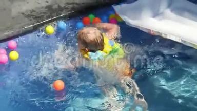 穿着袖子和帽子的小男孩正在度假时在游泳池里游泳。 男孩在热带的游泳池里游泳