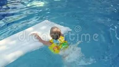 穿着袖子和帽子的小男孩正在度假时在游泳池里游泳。 男孩在热带的游泳池里游泳