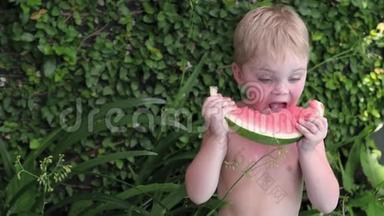 男孩夏天在院子里<strong>吃西瓜</strong>。 小孩子在度假<strong>吃</strong>水果