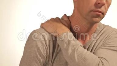 男人按摩他疼痛的肩膀，试图减轻疼痛的白色背景。 健康问题