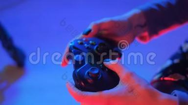 一个拿着操纵杆在电视上玩电子游戏的女孩的手。 玩游戏的人手拿游戏本。 一个女人在玩