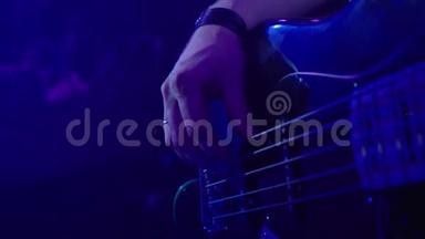 摇滚音乐家演奏五弦低音吉他.. 关闭低音吉他手的手指或手.