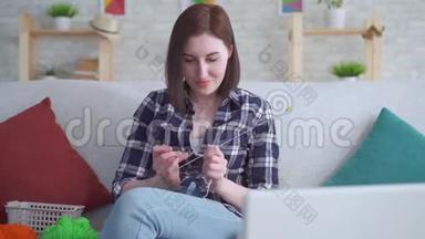 合上<strong>坐在</strong>笔记本<strong>电脑前</strong>沙发上学习编织的女人