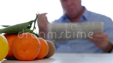 厨房里的男人，桌上有新鲜水果，在报纸上阅读和记录