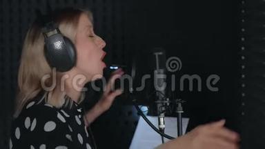 女歌手戴耳机唱歌，<strong>麦克风录音</strong>歌曲在<strong>录音</strong>室。