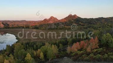 黄昏的秋景，在红日落日的光线下，岩石山和山的顶部