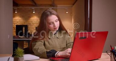 漂亮的十几岁女孩用笔记本电脑工作的肖像在办公室<strong>获得</strong>了成功。