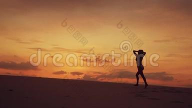 快乐自由女人在沙漠中奔跑的剪影