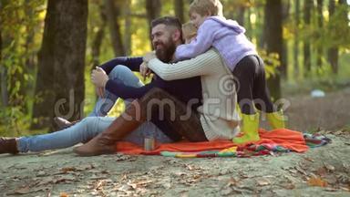 五彩缤纷的秋天家谱。 快乐微笑的年轻父母和小儿子躺在秋叶里。 年轻父母和