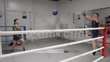 两名拳击手在拳击场上热身训练时投掷球。 拳击手在个人拳击前的训练