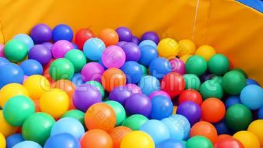 五颜六色的塑料球在游泳池里供儿童使用。 库存录像。 把很多彩色球放在操场上