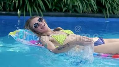 年轻迷人的女人在床垫上的<strong>游泳池</strong>里洗澡。 从上面看。 度假的女人在<strong>游泳池</strong>里游泳