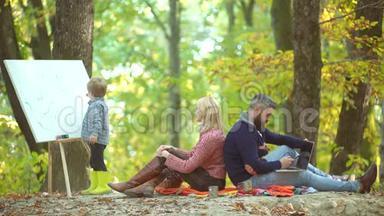 父母和儿子在户外玩得很开心。 浪漫的一对。 愉快的家庭野餐。 快乐儿童艺术家