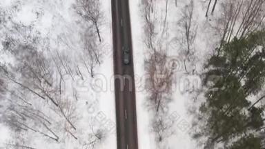 在冬季森林道路上驾驶汽车的鸟瞰图。 冬季风景。 顶级追踪镜头。