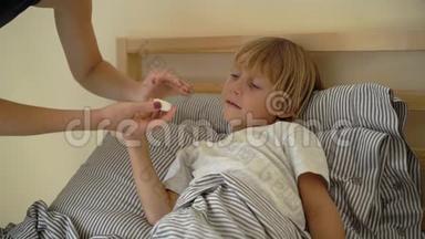 一个生病的小男孩躺在床上的超慢镜头。 母亲用精油`男孩的胸部涂抹药膏. 婴儿流感
