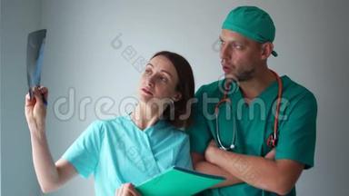 两名医生，一名男子和一名妇女正在检查一张病人的X光照片。 医务人员讨论x光结果