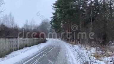 俄罗斯的冬天。 暴风雪席卷而来。 在冬天的森林里扫过沥青路。 `下雪了。 松林。 暮光之城。 4K