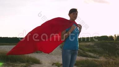 穿着红色雨衣的超级英雄女孩迎风微笑。 一个年轻女孩<strong>梦想</strong>成<strong>为</strong>超级英雄。 女孩走路
