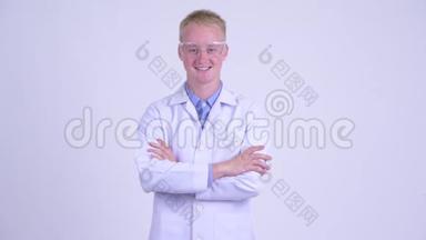 戴着防护眼镜、双臂交叉的年轻金发医生