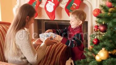 小男孩在圣诞节早上给他妈妈送礼物的4K镜头。 家庭捐赠和接受新年