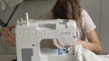 一个女人在家庭作坊的缝纫机上缝衣服