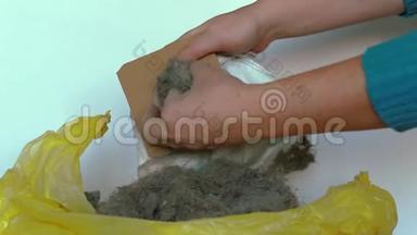 女人`手清洁吸尘器的袋子，从袋子里拿出灰尘和污垢