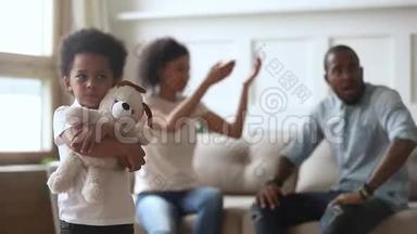 <strong>父母吵架</strong>时，不快乐的小非洲儿子拥抱玩具