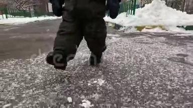 一个小孩子的脚在冬天的雪和柏油路上迈出我的<strong>第一</strong>步。 小宝宝学会走路.. <strong>第一</strong>批