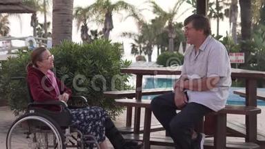 一位坐轮椅的老妇人正在旅馆里和丈夫谈话