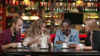 一家由朋友组成的跨国公司在餐馆里喝咖啡和聊天。 四个朋友聊天。