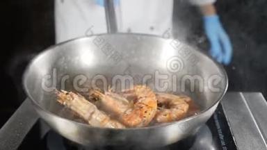 煎锅上正在准备炸虾。 厨师在锅上辗转、混合和投掷海鲜，特写慢动作