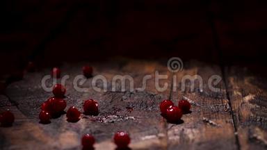 成熟的新鲜蔓越莓落在黑暗的木制乡村桌子上。 库存录像。 把木头表面和
