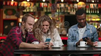 一群朋友在酒吧喝咖啡，边看智能<strong>手机屏</strong>幕边讨论