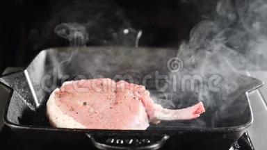 厨师用平底锅在黑色背景下烹饪<strong>炒肉</strong>牛排，蒸汽从盘子中缓慢上升，食物大师级，食物